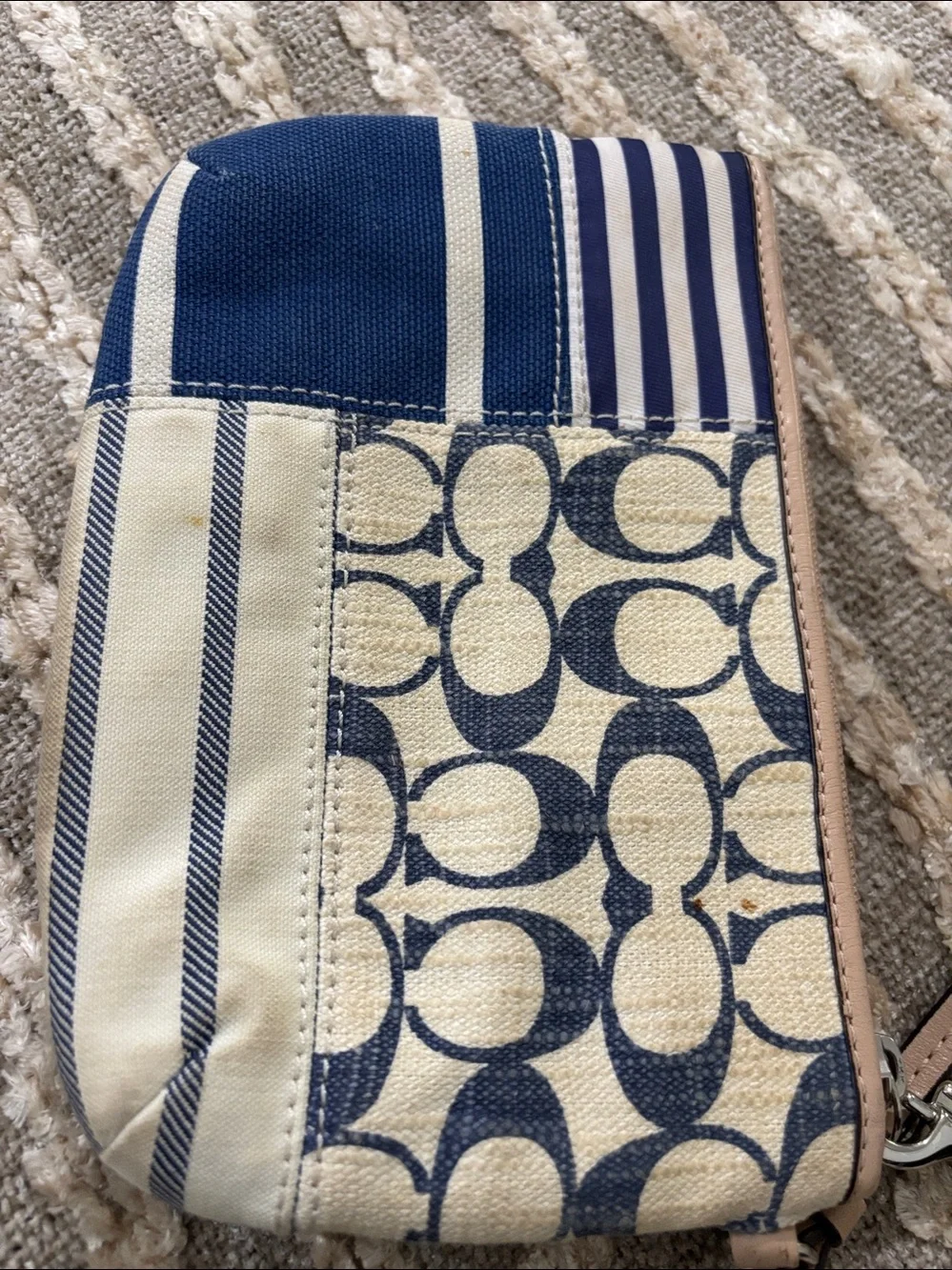 Coach wristlet featuring signature patchwork print in navy and cream